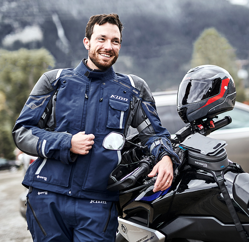 Guy leaning on bike wearing Klim Kodiak suit